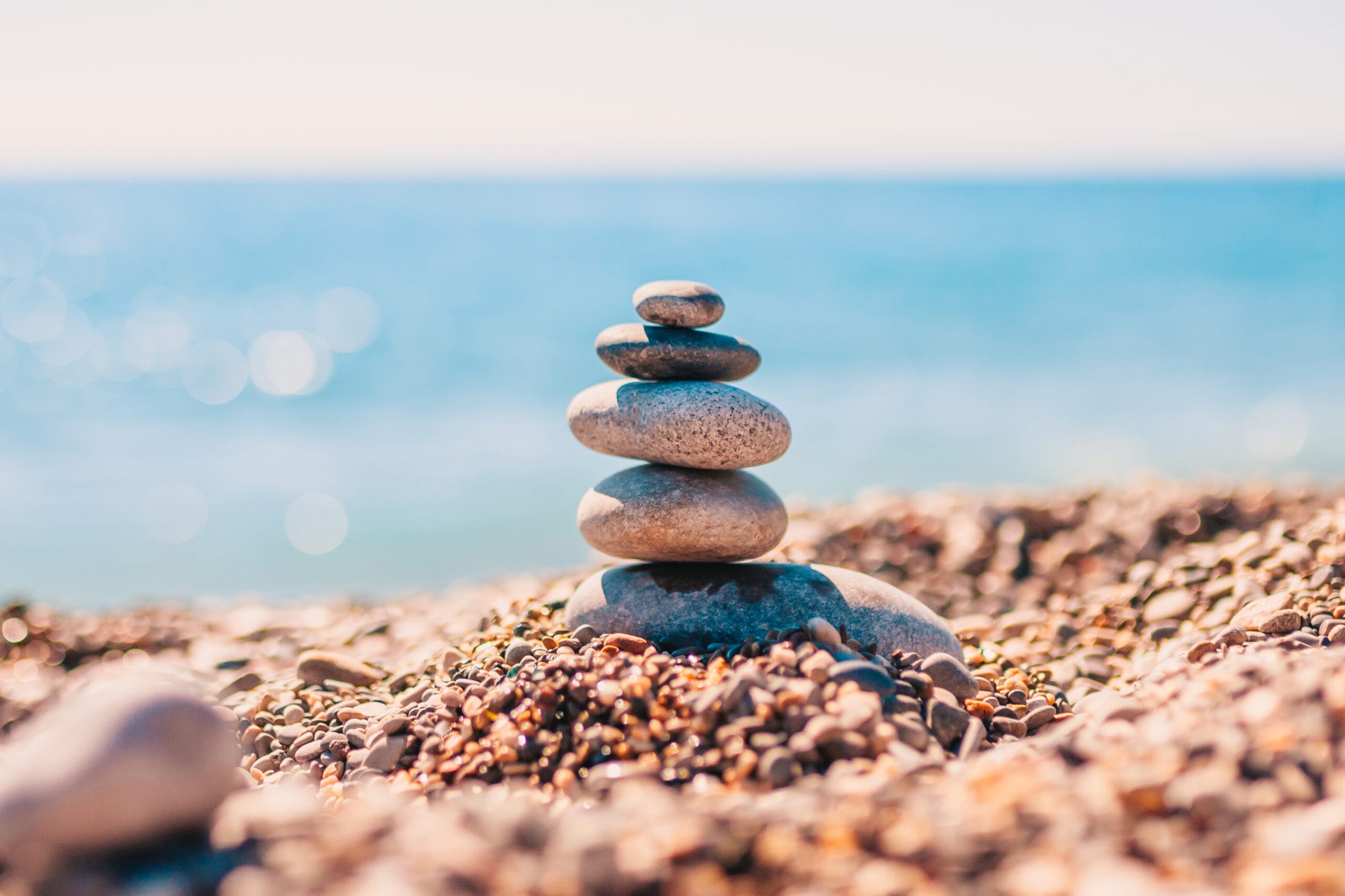 Stone pyramid on pebbles on beach - zen rock - balance and harmony