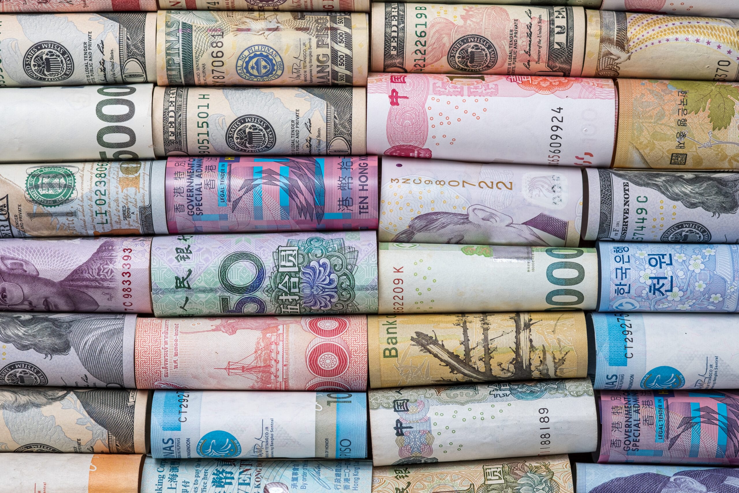 Closeup rolled of variety banknote and multi currency around the world. Exchange rate and Forex investment concept.-Image.
